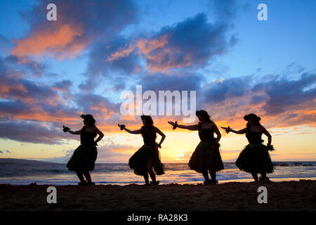 Vier Hula Tänzer mit einem spektakulären Sonnenuntergang am Strand Palauea, Maui, Hawaii. Stockfoto