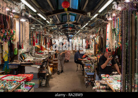 Abschaltdruck Inhaber bei Hong Kong's berühmten Jade Markt mit ihren bunten Displays von Jade Armbänder, Perlen und Schmuckstücke. Stockfoto