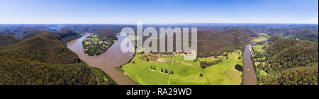 Wisemans Ferry Stadt am Ufer des Hawkesbury River an der entrayce von Macdonald Fluss in einem weiten grünen Tal zwischen den Bergketten im Bild von abov Stockfoto