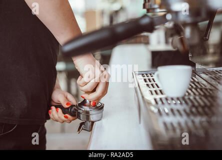 Barista Pressen gemahlenen Kaffee verwenden. Nahaufnahme auf Händen Stockfoto
