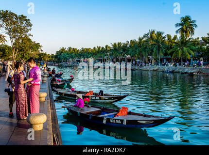 Ein Paar halten sich an den Händen tragen Thai Kleidung neben dem Fluss, in der Alten Stadt Hoi An. Stockfoto