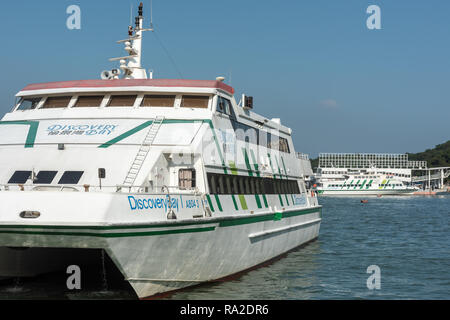 Die Discovery Bay 1 high speed Catamaran Fähre günstig bei Nim Shue Wan Ferry Pier auf Lantau mit Discovery Bay 19 im Hintergrund Stockfoto