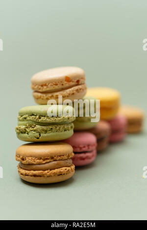 Vintage pastellfarbenen Französische Makronen oder Macarons auf grünem Hintergrund Stockfoto