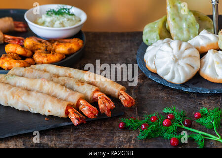 Riesige Riesengarnelen und Auswahl von Mini chinesischen Teigtaschen mit Joghurt tauchen Saucen. Party Food Idee. Stockfoto