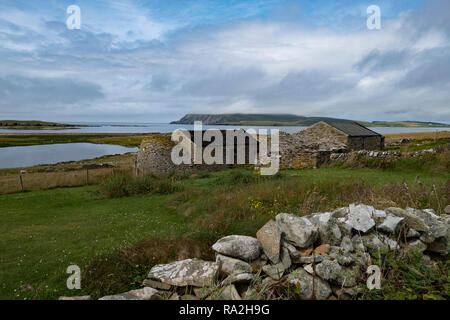 Eine alte Croft Haus mit Steinmauern mit Blick auf den Atlantischen Ozean in der schottischen Shetland-Inseln auf einem leicht bewölkt Tag Stockfoto