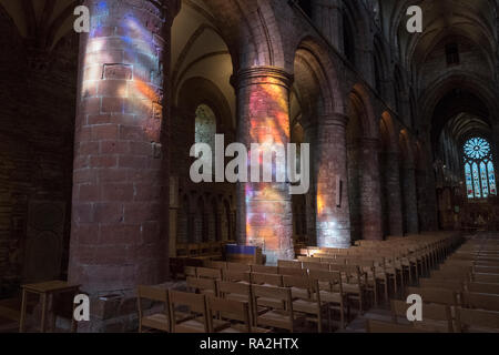 Innenraum Bögen von St. Magnus Kathedrale in Kirkwall beleuchtet durch einen Regenbogen von Licht durch die Glasfenster der westlichen Fassade kommen Stockfoto