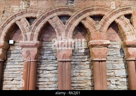 Interior Detail der verschlungenen Bögen aus mehrfarbigem in rotem Sandstein, die St. Magnus Kathedrale, Kirkwall, Orkney Inseln Stockfoto