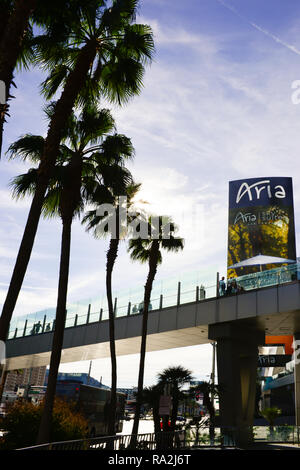 Ein 7/8-Ansicht von Menschen zu Fuß in Silhouette über die Fußgängerbrücke, die über den Las Vegas Strip in Las Vegas, NV, Kreuze, in der Nähe der Aria Hotel Stockfoto