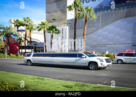 Eine weiße Cadillac-Stretch-Limousine, die an einem sonnigen Tag auf dem von Palmen gesäumten Las Vegas Strip vor dem Linq Hotel and Casino in Las Vegas, NV, fährt Stockfoto