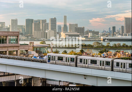 Tokyo Yurikamome Monorail Zug bei Odaiba mit der Tokyo Skyline im Hintergrund, Japan Stockfoto