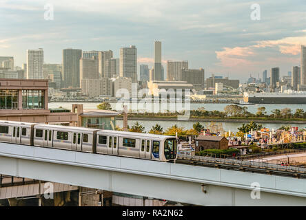 Tokyo Yurikamome Monorail Zug bei Odaiba mit der Tokyo Skyline im Hintergrund, Japan Stockfoto