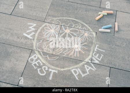 Kinder Zeichnung mit farbigen Kreiden auf Asphalt - Planet Erde mit bunten Blumen und Text - meine besten Planeten. Stockfoto