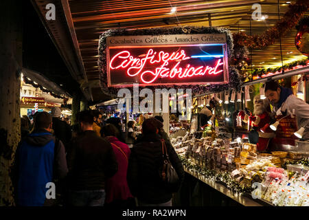 Traditionelles Essen stand auf dem Weihnachtsmarkt in Straßburg bei Nacht, Place Broglie, Elsass, Frankreich. Stockfoto