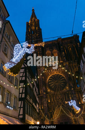 Beleuchteten Kathedrale von Straßburg bei Nacht mit Weihnachtsschmuck und Lichter über der Straße hängen, Dezember, Frankreich, Europa. Stockfoto