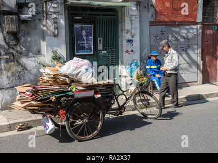 Lokale Arbeiter sammelt Karton für das Recycling bei Fahrrad Stockfoto