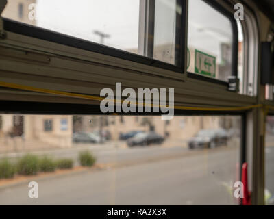 Gelben bus Reißleine thront oben auf Fenster mit Stadt zoomen Stockfoto