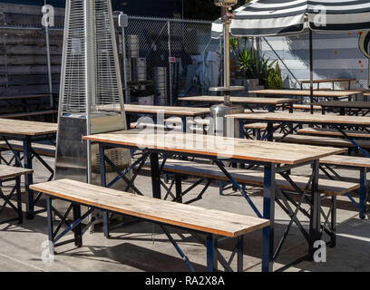 Outdoor Picknick Tischen und Sonnenschirmen in einem Außenbereich Restaurant Brauerei Essbereich während der sonnigen Tag Stockfoto