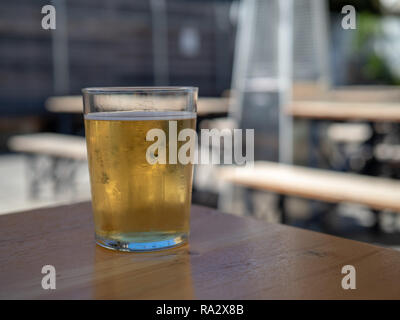 Kaltes Licht Bier sitzen im frostigen Glas im Picknickbereich im Freien Stockfoto