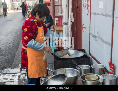 Frau an der Seite der Straße Kochen im Wok Stockfoto