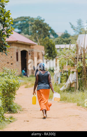 Frau, die Wasser in Entebbe, Uganda, trägt Stockfoto