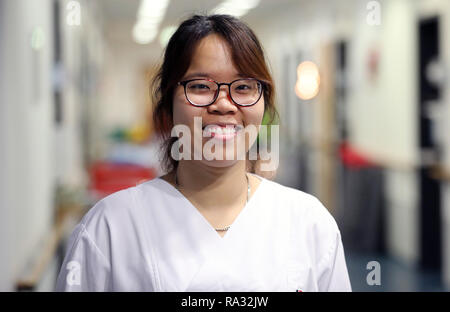 Rostock, Deutschland. 21 Dez, 2018. Anh tu tun, einer von 20 jungen Vietnamesen, die ihre Ausbildung in der Krankenpflege in der universitären Medizin an der Ende August 2018 begann, steht auf dem Flur der Onkologie. Wie erwartet, der Umgang mit der Deutschen Sprache ist immer noch schwierig, aber von der technischen Seite gibt es keine Probleme mit den 16 Frauen und 4 Männer aus Vietnam. Quelle: Bernd Wüstneck/dpa/Alamy leben Nachrichten Stockfoto