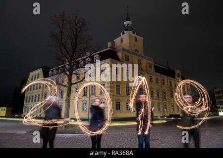 Oldenburg, Deutschland. 31 Dez, 2018. Am Silvesterabend, vier Personen stehen vor dem Oldenburger Schloss und schreiben das Jahr 2019 mit brennenden Wunderkerzen (lange Belichtungszeit). Credit: mohssen Assanimoghaddam/dpa/Alamy leben Nachrichten Stockfoto