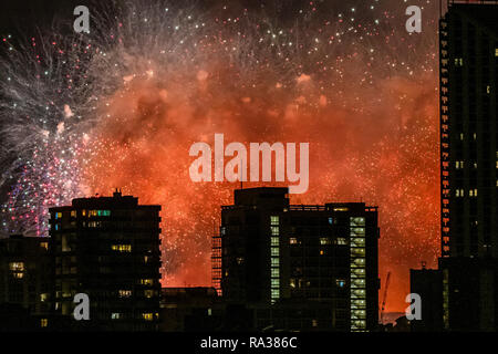 London, Großbritannien. 1. Jan 2019. Die neuen Jahre Tag Feuerwerk in London gesehen Hintern Wohnblocks aus Richtung elelphant und die Burg. Credit: Guy Bell/Alamy leben Nachrichten Stockfoto