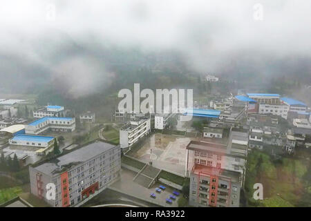 (190101) - JULIAN, JAN. 1, 2019 (Xinhua) - Foto am Dez. 8, 2018 zeigt die Ariel Ansicht der Gebäude in Haoba Central Schule und der benachbarten Gemeinden in der Stadt Yibin Junlian County im Südwesten der chinesischen Provinz Sichuan. In der riesigen Wumeng Berge im Südwesten Chinas Provinz Sichuan, Haoba Central School ist eine neunjährige Schule die Grundschule und Mittelschule, nur wie andere Schulen in dieser Bergwelt. Jedoch eine Basketballmannschaft von weiblichen Studenten gebildet, die Schule ziemlich berühmt in seiner Gemeinde, auch in benachbarten Städten. Das team Stockfoto