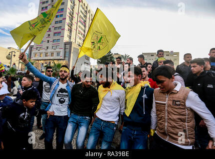 Demonstranten gesehen halten Sie die gelben Flaggen während des Protestes. Palästinenser skandierten Parolen und schwenkten Fahnen der gelben Fatah-bewegung während einer Demonstration anlässlich des 54. Jahrestages der Fatah Bewegung in der Stadt Gaza. Stockfoto