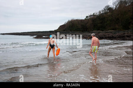 Myrtleville, Cork, Irland. 1. Januar, 2019. Klara Droog, Crosshaven und Adrian Cleary, Myrtleville Kopf ins Meer für Ihre erste schwimmen des Jahres an Myrtleville Strand, Co Cork, Irland. Quelle: David Creedon/Alamy leben Nachrichten Stockfoto