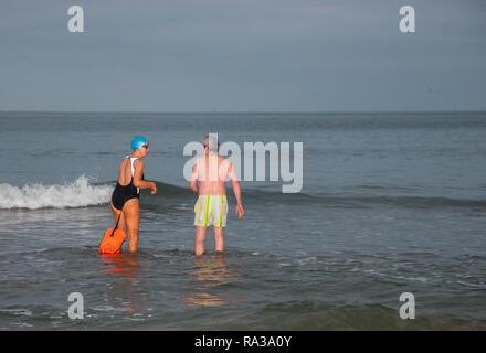 Myrtleville, Cork, Irland. 1. Januar, 2019. Klara Droog, Crosshaven und Adrian Cleary, Myrtleville Kopf ins Meer für Ihre erste schwimmen des Jahres an Myrtleville Strand, Co Cork, Irland. Quelle: David Creedon/Alamy leben Nachrichten Stockfoto