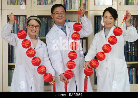 (190101) - CANGZHOU, Januar 1, 2019 (Xinhua) - China - Leute - NEUES JAHR - hoffnungsvoll 2019 (KN) Ärzte (L-R) Er Xinying, Sun Yunchuan und Xiao Li zeigen ihre Neujahrswünsche geschrieben am roten Laternen in Cangzhou, im Norden der chinesischen Provinz Hebei, Jan. 1, 2019. Ihre Wünsche sind: Eltern öfter sehen, Hundert armen Menschen zu helfen und weitere Ausbildung in Peking zu nehmen. (Xinhua/Fu Xinchun) Stockfoto