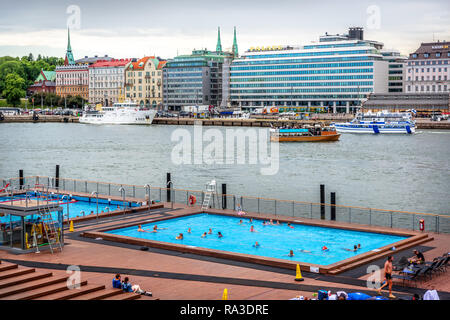 Helsinki, Finnland - 10. Juni 2018 - Einheimische und Touristen Spaß im Freien öffentlichen Schwimmbad von Helsinki mit Schiffen und Gebäuden in der b Stockfoto