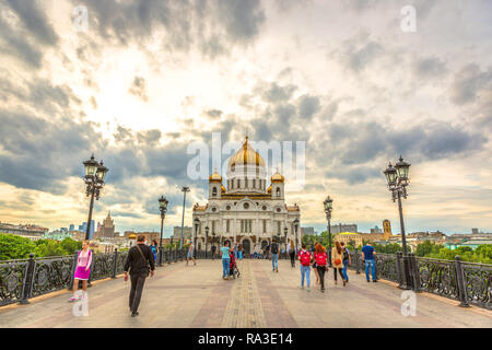 Moskau, Russland - Juni 4 2018 - eine große Gruppe von Menschen über eine Brücke vor einem riesigen Kirche mit goldenen Kuppel in einem späten Nachmittag Licht in Mosco Stockfoto