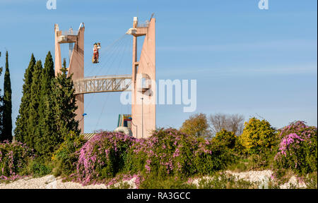 Sevilla Spanien GEBÄUDE AUF DER EXPO 92 SITE ABBILDUNG VON MANN UND BIER VOM FASS AM UFER DES FLUSSES GUADALQUIVIR mit ORANGENBÄUMEN und Bougainvillea. Stockfoto