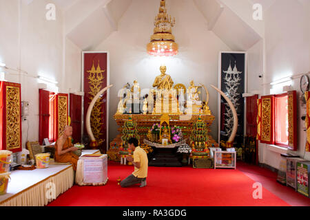 Asiatische thai Mann Respekt beten mit Mönchen und Buddha Statue im ubosot am Wat Phra That Doi Tung am 22. Februar 2018 in Chiang Rai, Thailand Stockfoto