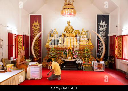 Asiatische thai Mann Respekt beten mit Mönchen und Buddha Statue im ubosot am Wat Phra That Doi Tung am 22. Februar 2018 in Chiang Rai, Thailand Stockfoto