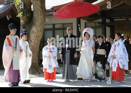 Shinto Hochzeit Prozession mit Braut das Tragen der traditionellen watabōshi Weiße Haube mit Bräutigam in der Meiji Jingu Shinto Schrein Stockfoto