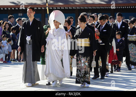 Shinto Hochzeit Prozession mit Braut das Tragen der traditionellen watabōshi Weiße Haube mit Bräutigam in der Meiji Jingu Shinto Schrein Stockfoto