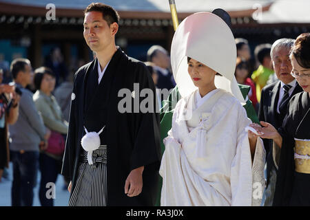Shinto Hochzeit Prozession mit Braut das Tragen der traditionellen watabōshi Weiße Haube mit Bräutigam in der Meiji Jingu Shinto Schrein Stockfoto