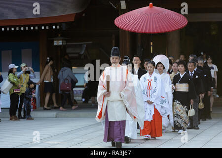 Shinto Hochzeit Prozession mit Braut das Tragen der traditionellen watabōshi Weiße Haube mit Bräutigam in der Meiji Jingu Shinto Schrein Stockfoto