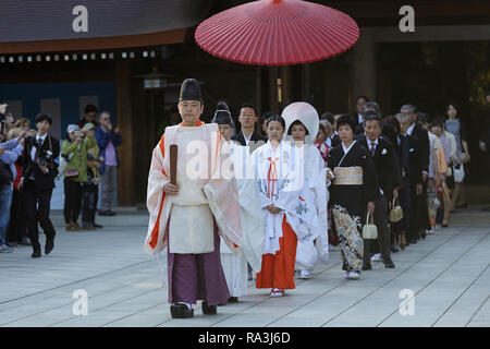 Shinto Hochzeit Prozession mit Braut das Tragen der traditionellen watabōshi Weiße Haube mit Bräutigam in der Meiji Jingu Shinto Schrein Stockfoto