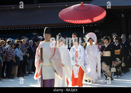 Shinto Hochzeit Prozession mit Braut das Tragen der traditionellen watabōshi Weiße Haube mit Bräutigam in der Meiji Jingu Shinto Schrein Stockfoto