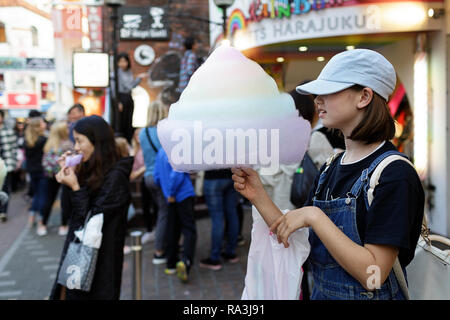 Ein japanisches Mädchen mit bunten Baumwolle Zuckerwatte auf Takeshita Straße im Stadtteil Harajuku in Tokio, Japan. Stockfoto