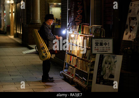 Kunden Bücher lesen auf der Straße vor einer Buchhandlung, Jimbocho, Kanda, Chiyoda, Präfektur Tokio Stockfoto