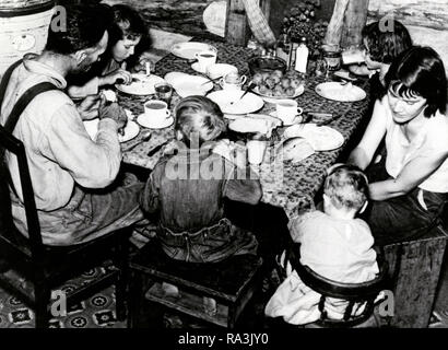 Familie essen Mahlzeit der hominy Grits, Brei, Melasse, Kohl, Kartoffeln und Reis. 1920 Stockfoto