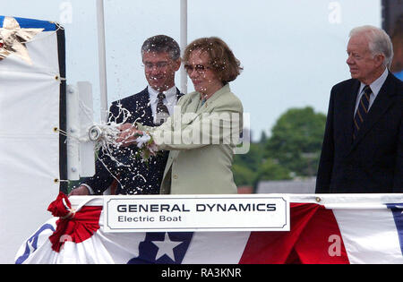 Ehemalige First Lady Rosalynn Carter zertrümmert, eine Flasche Champagner gegen das Segel der US Navy (USN) SEAWOLF CLASS: Angriffs-U-Boot, die USS Jimmy Carter (SSN 23), während das Schiff Taufe, gehalten an der elektrische Boot Corporation von Connecticut, in Groton, Connecticut (CT). Auch dargestellt sind: Herr John S. Casey (links), Präsident, Elektroboot Division, und der ehemalige US-Präsident Jimmy Carter, Namensgeber des Schiffes. Stockfoto