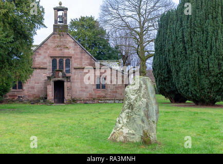 Vordere Tür der Kapelle der Jungfrau Maria an, High Legh, Cheshire, England, UK mit dem Millenium Stein im Vordergrund. Stockfoto