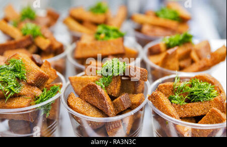 Roggenbrot Knoblauch Croutons mit Dill als Snack closeup in Plastikbechern Stockfoto