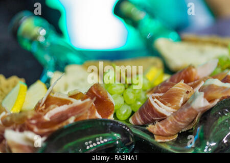 Snacks Sorten mit jamon, Birnen, Trauben und Brot auf Glasplatte closeup Stockfoto